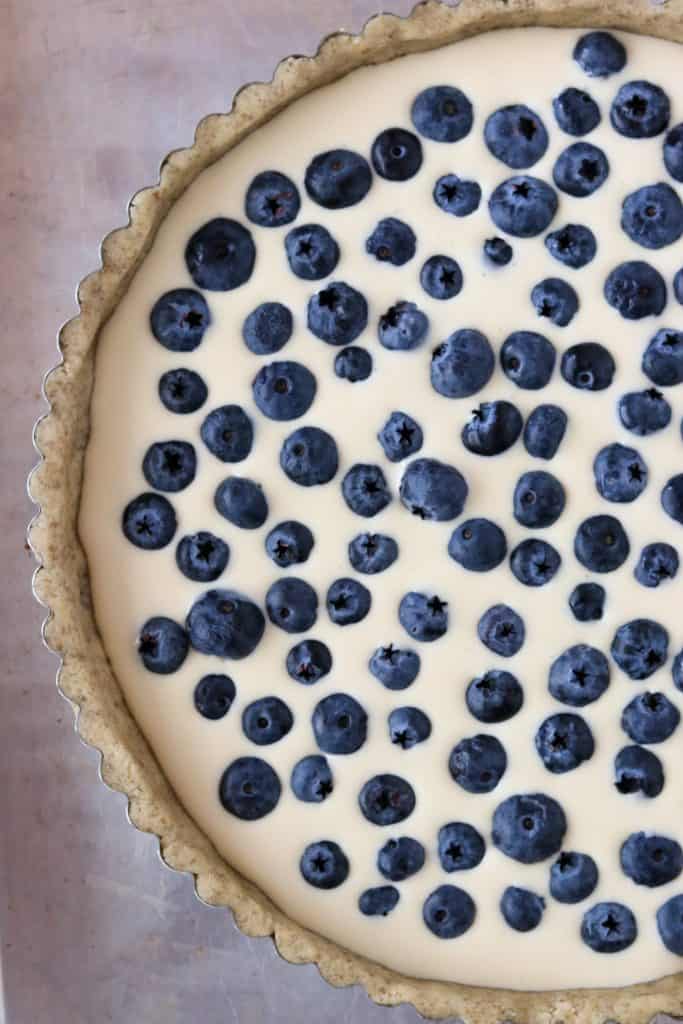 A close up of an unbaked blueberry tart