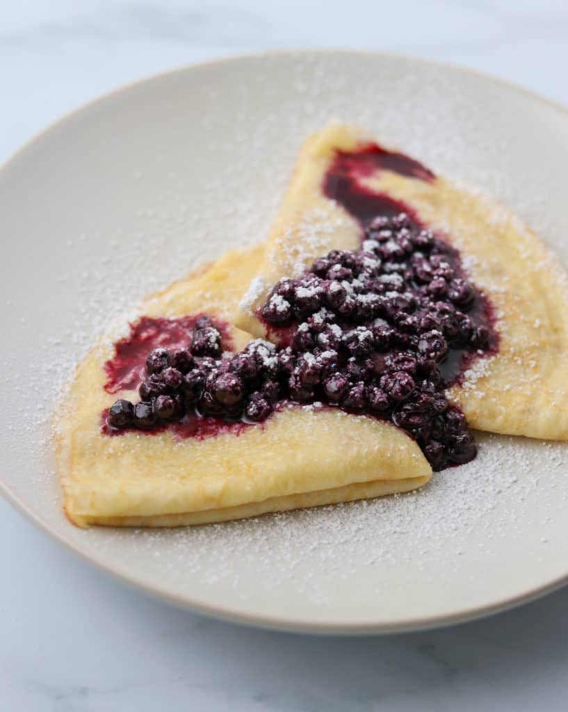 Swedish pancakes on a plate with blueberry compote