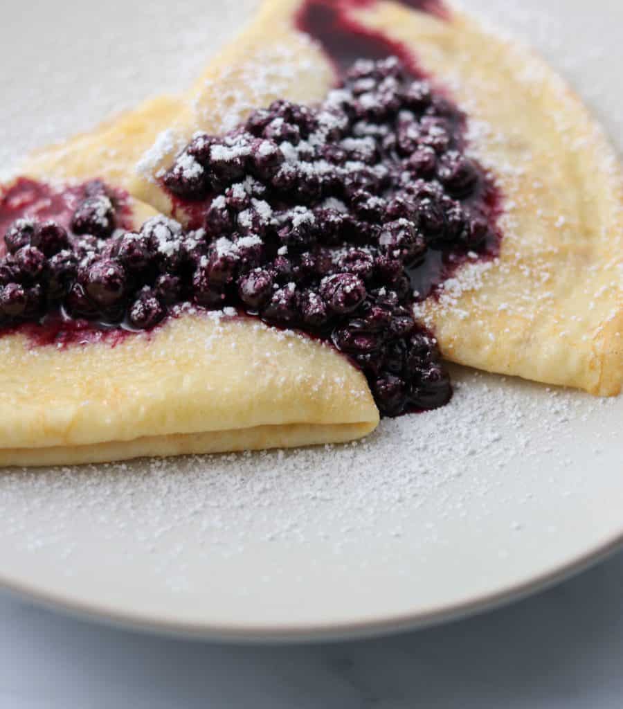 Swedish pancakes on a plate with blueberry compote