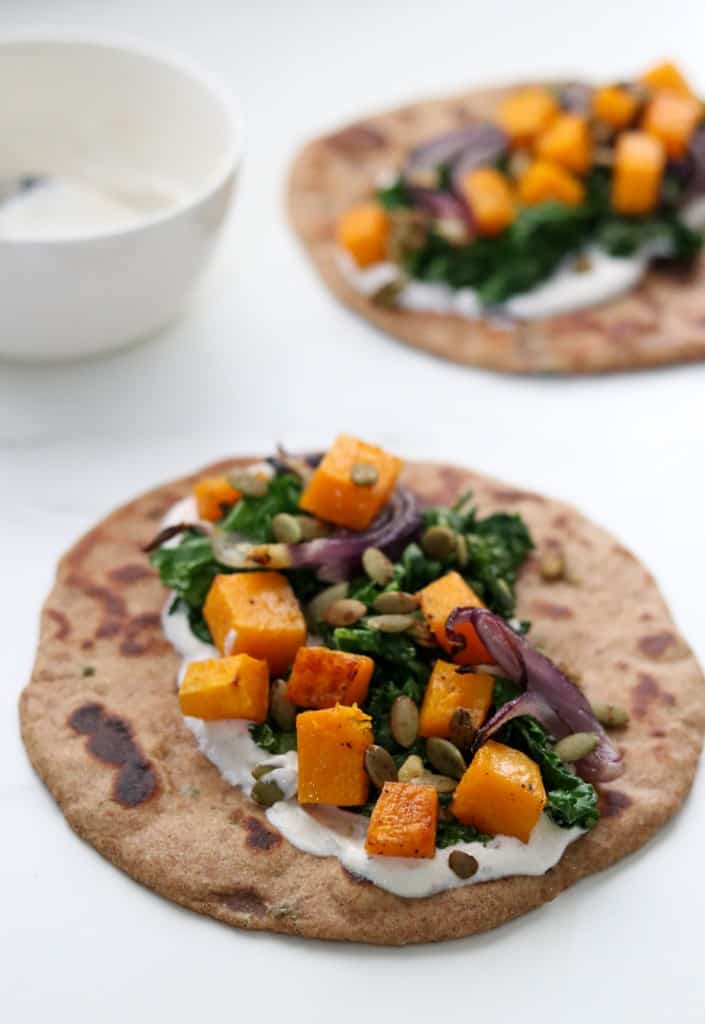 Flatbread topped with a creamy sauce and vegetables