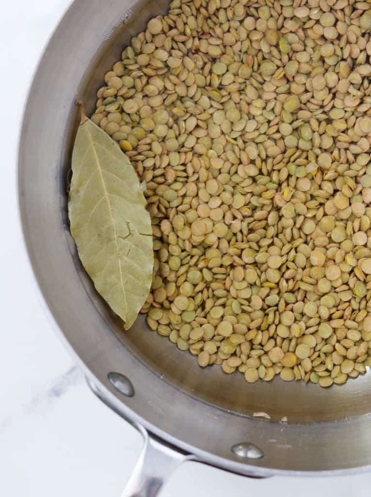 Lentils, water and a bay leaf in a pan