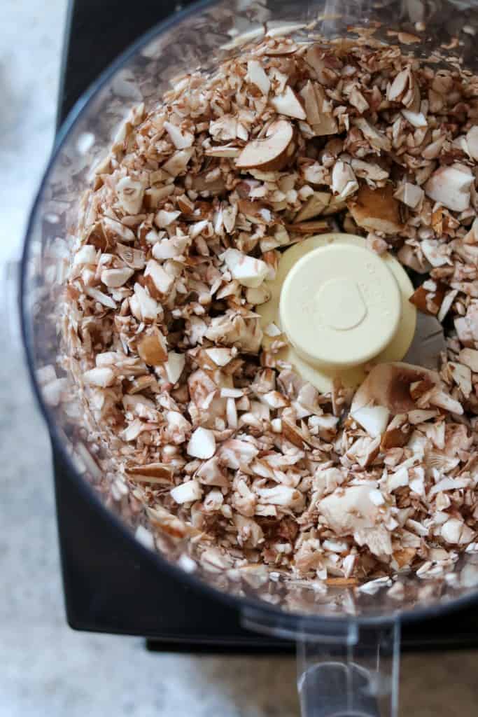 Close up of chopped mushrooms in a food processor work bowl