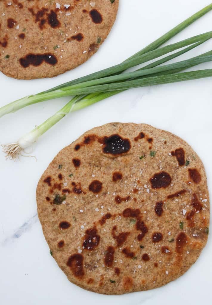 Flatbreads on a countertop with scallions