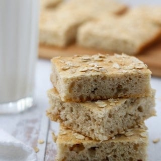A close up of a stack of Finnish flatbread slices next to a napkin and glass of milk