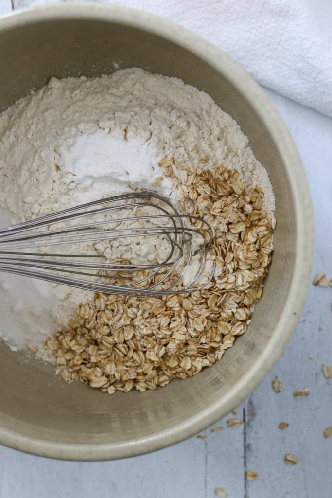Bowl filled with flour and oats with a whisk