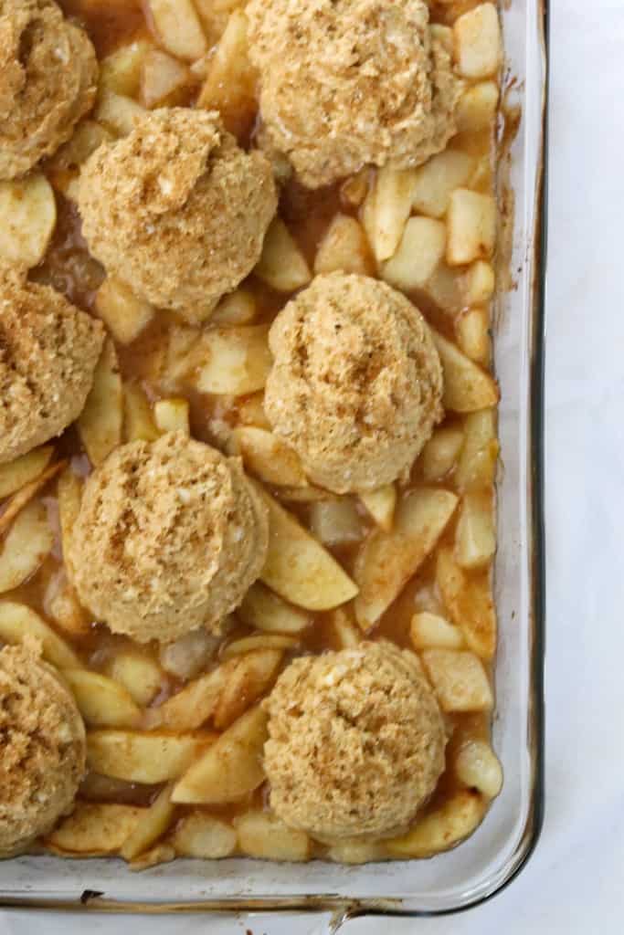 Unbaked gingerbread cobbler with apples and pears in a baking dish