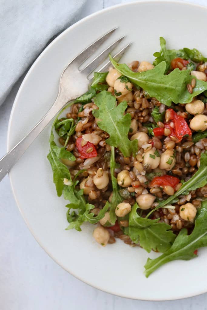 rye berry and chickpea with arugula on a plate