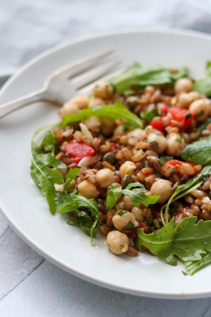 Rye berry and chickpea salad on a plate with a fork