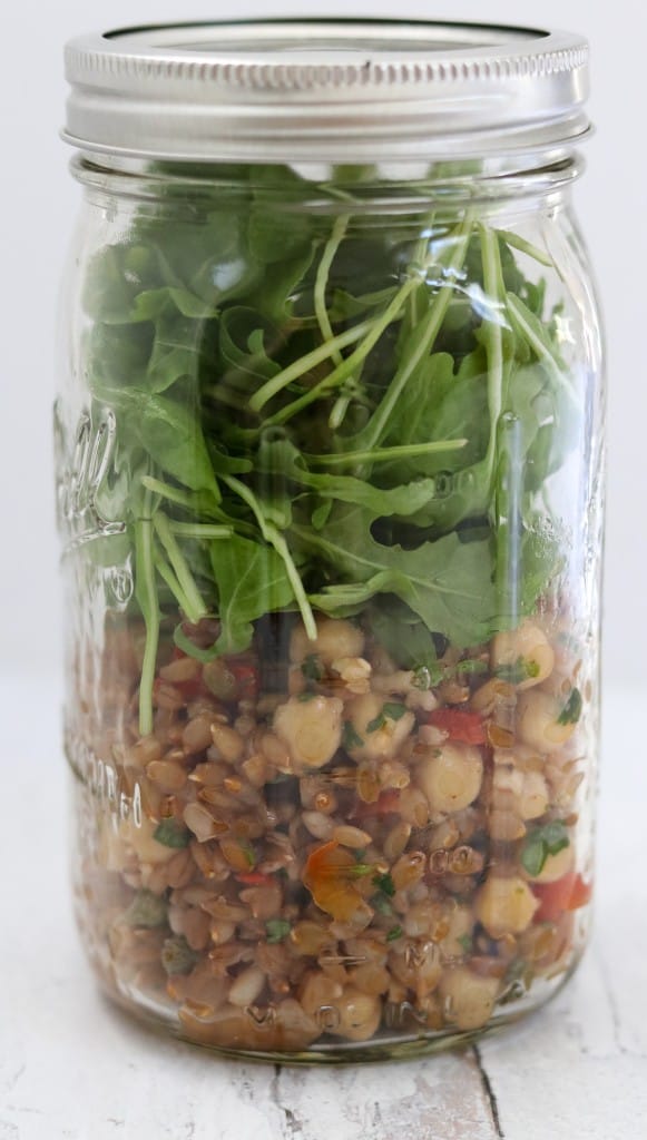 Rye berry salad and arugula leaves in a jar