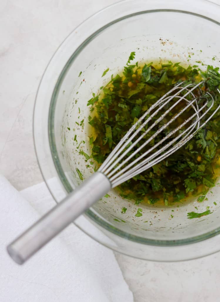 herbed vinaigrette in a bowl with a whisk