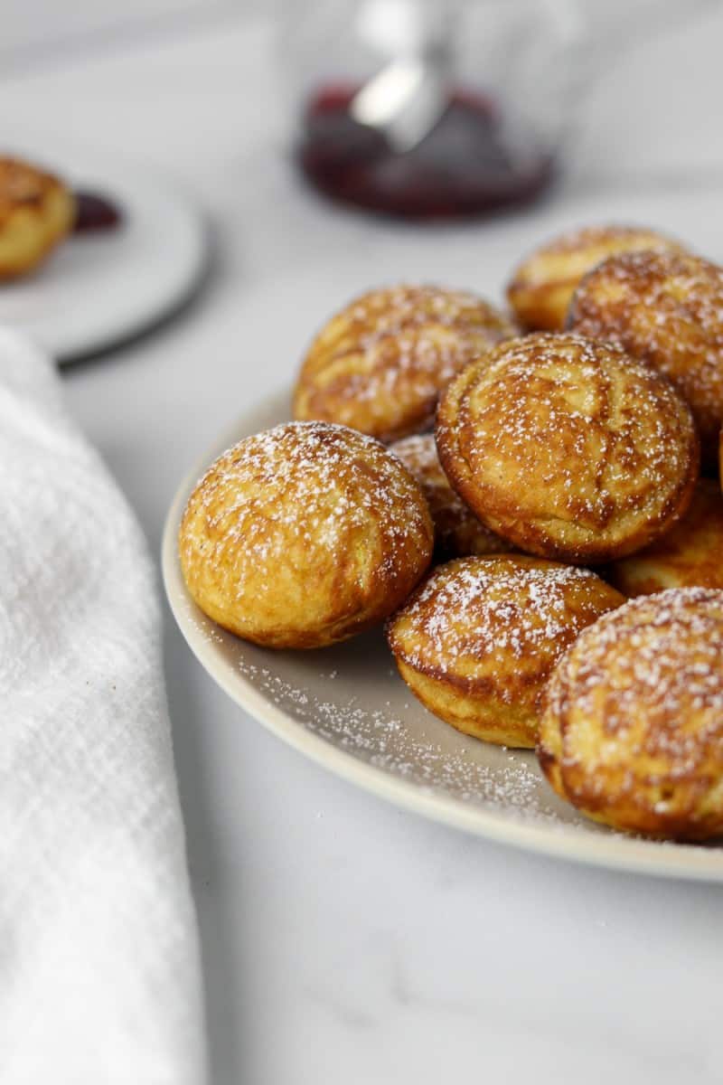 Close up of æbleskivers on a plate next to a napkin.