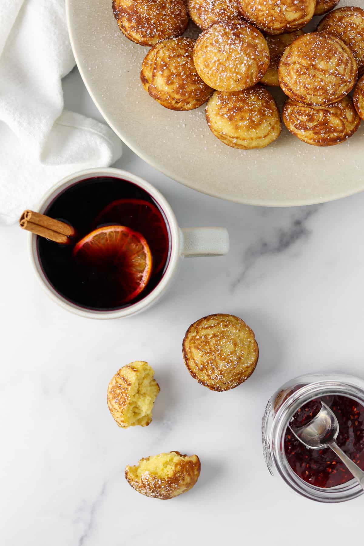 Æbleskivers, jam and mulled wine on a marble surface.