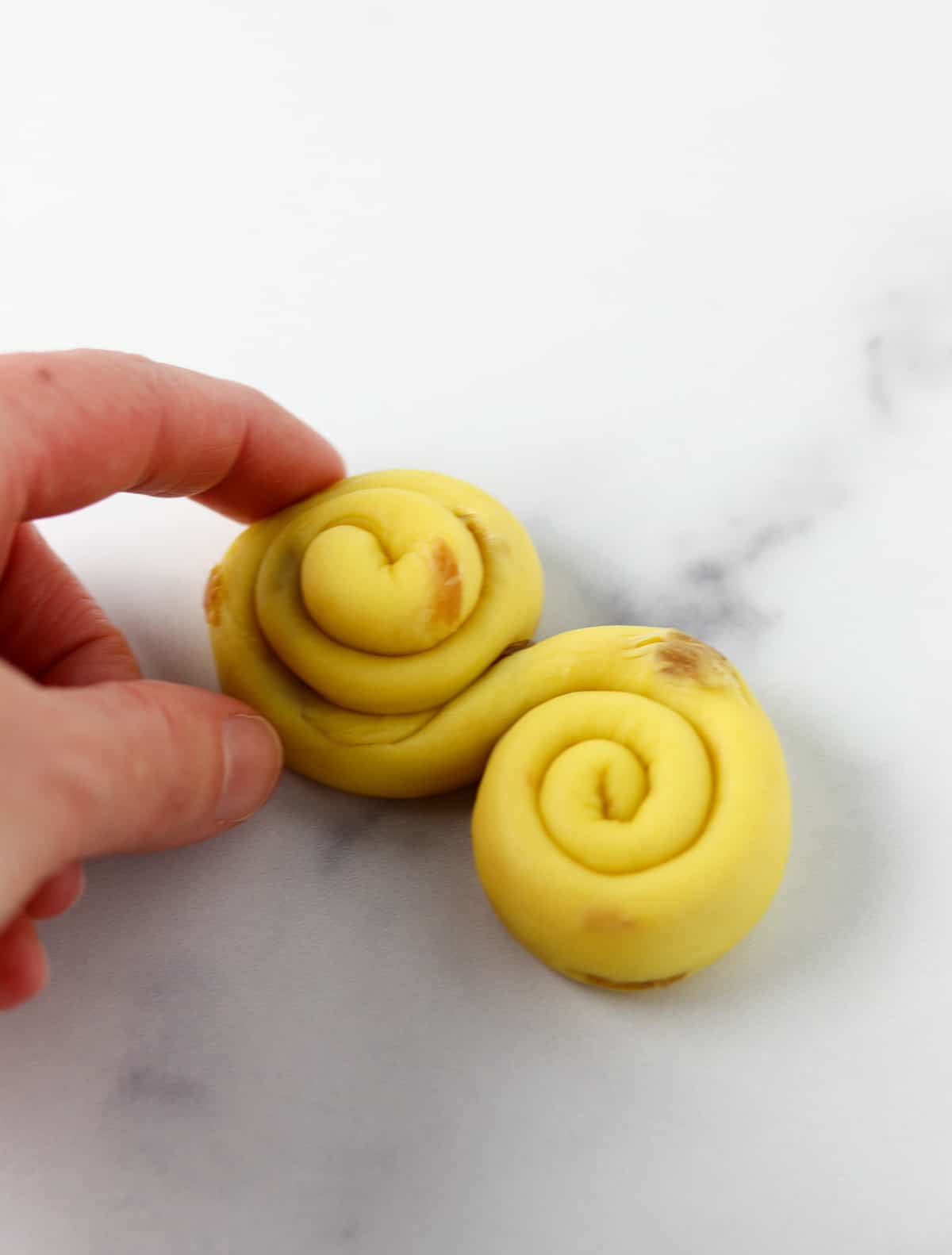 Person shaping St. Lucia Buns.