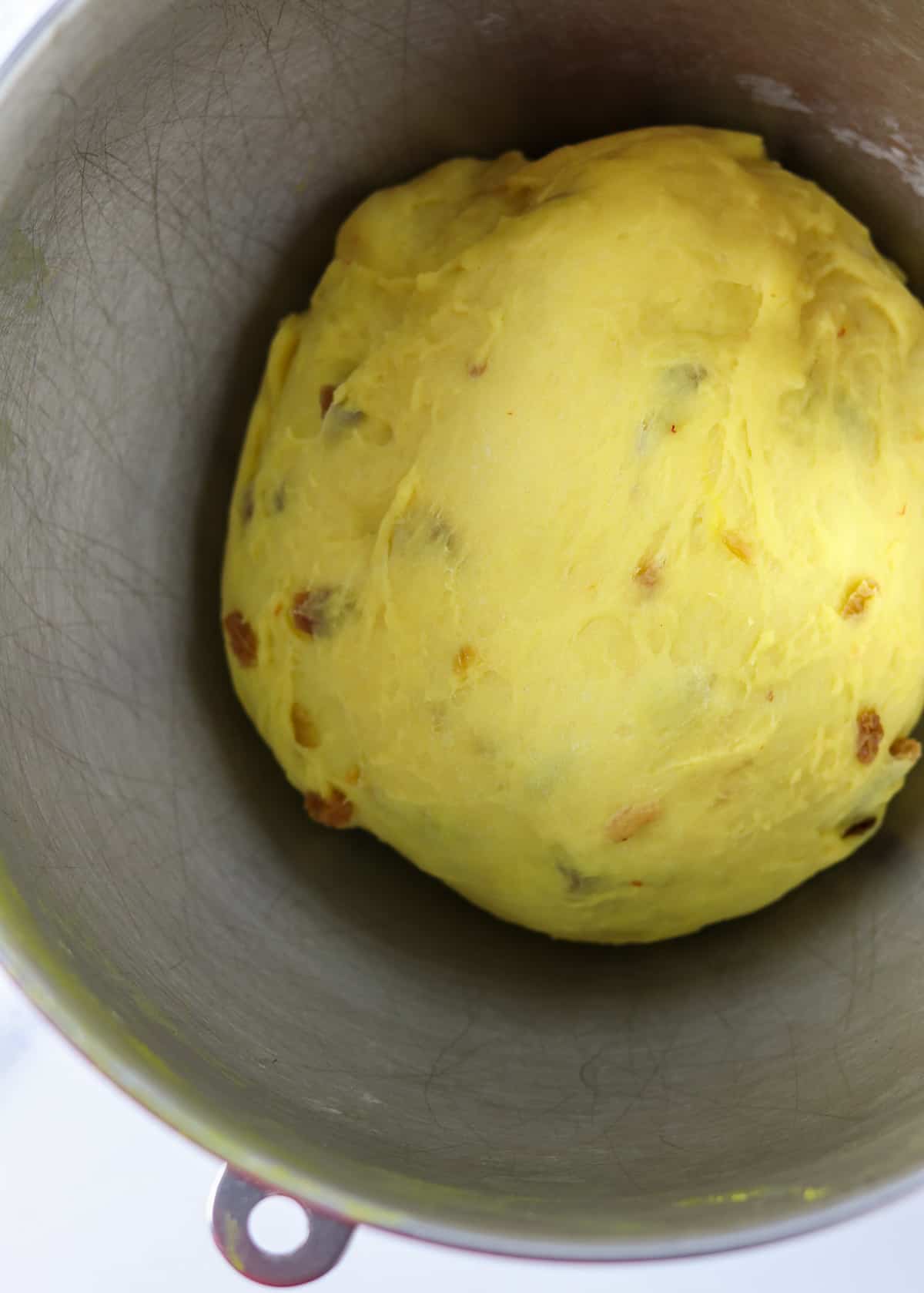 Saffron bread dough in a metal bowl.
