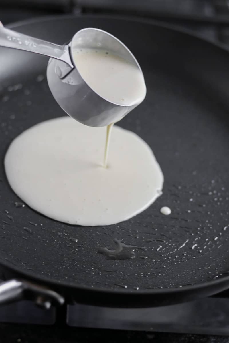Pancake batter being poured into a skillet.