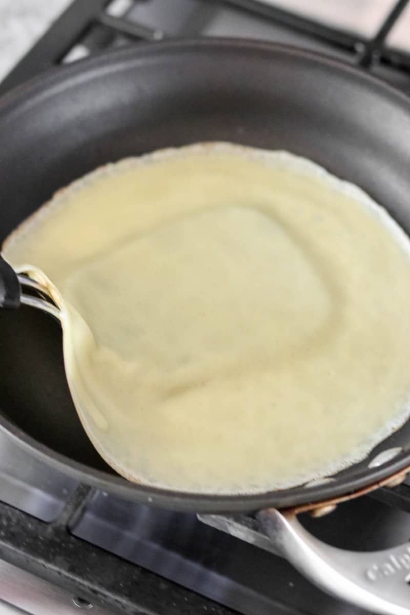 Swedish pancake in a pan wit a spatula underneath it.