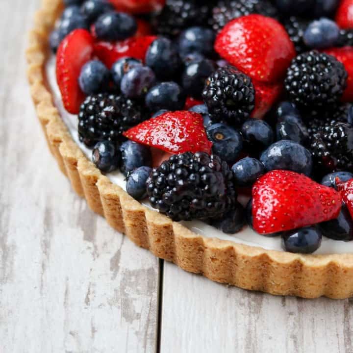 Mixed berry tart on a wooden surface.