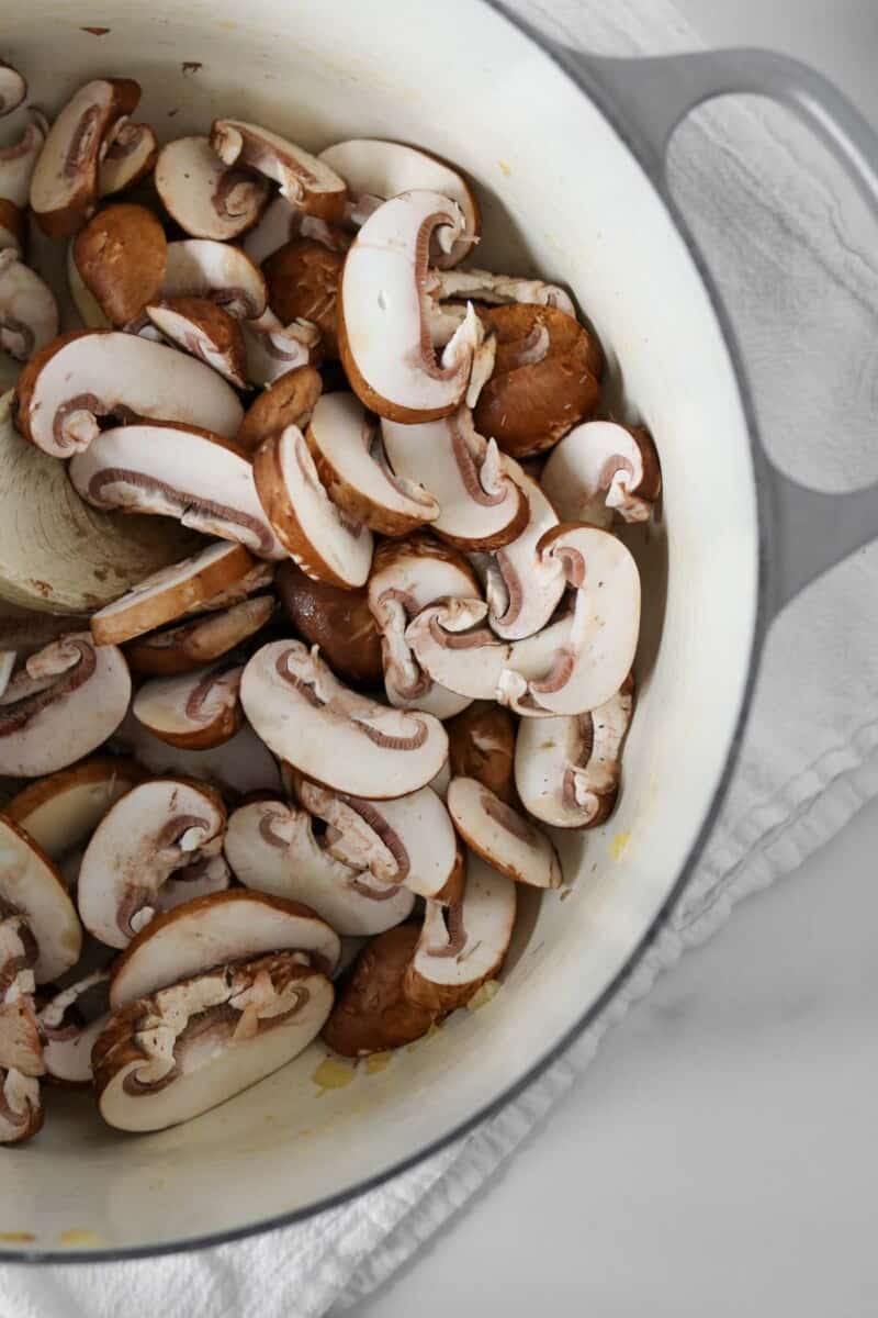Sliced raw mushrooms in a pot.