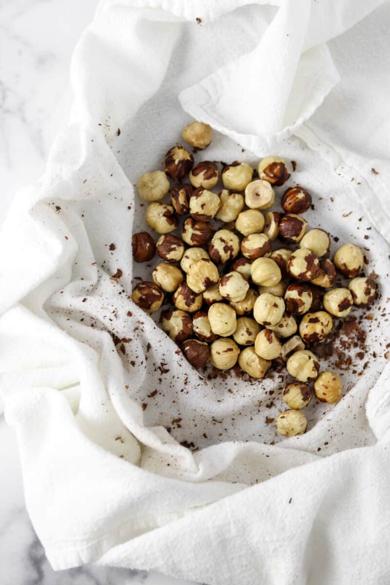 Roasted hazelnuts on a kitchen towel.