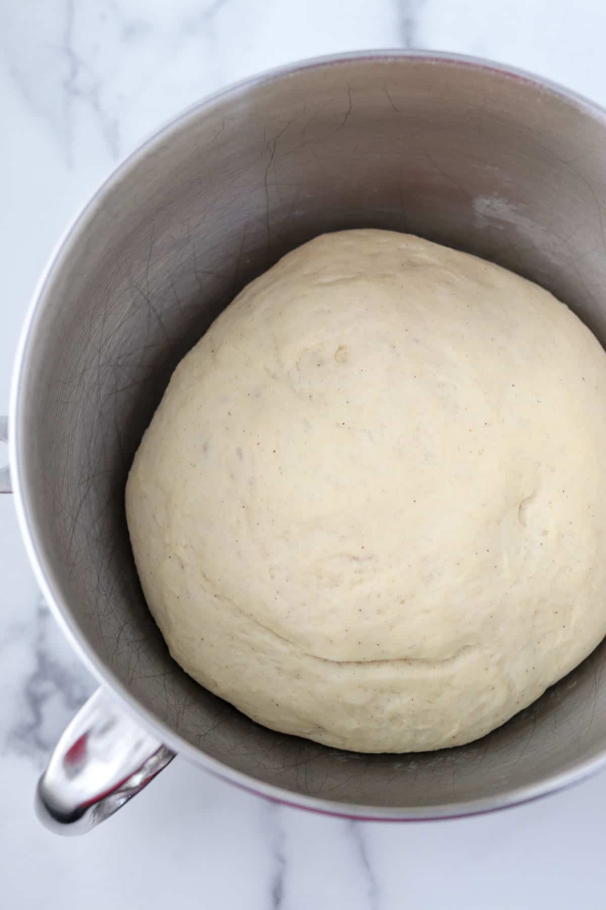 Bread dough in a metal bowl.
