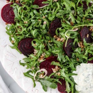 Roasted beet salad on a platter next to a napkin.