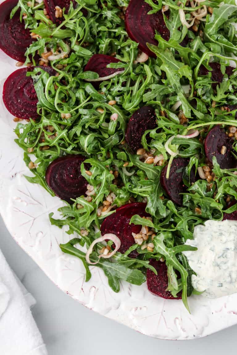 Roasted beet salad on a platter next to a napkin.