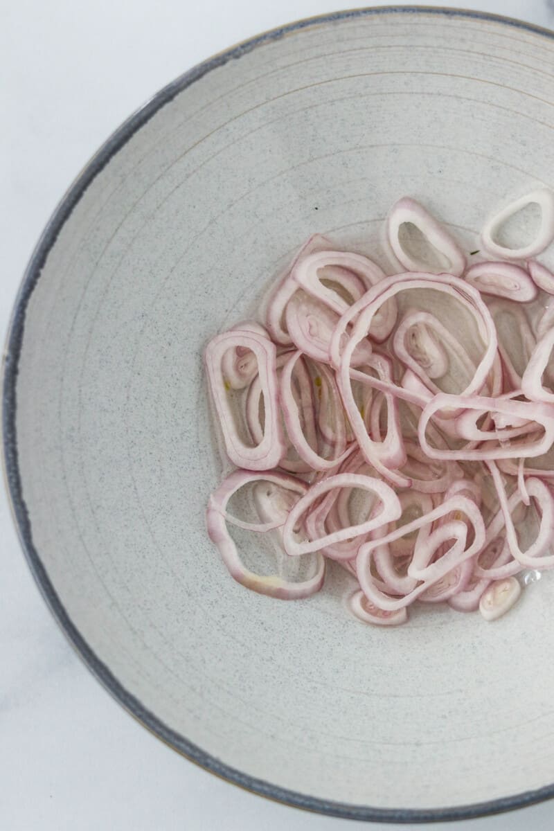 Sliced shallots in a bowl.
