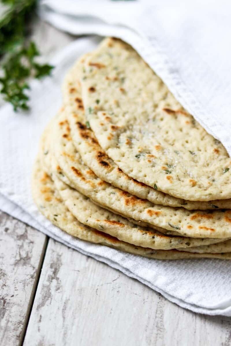 Soft flatbreads stacked on a towel.