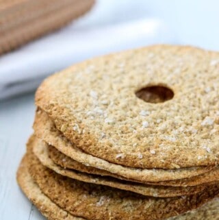 Swedish crispbread stacked next to a rolling pin.