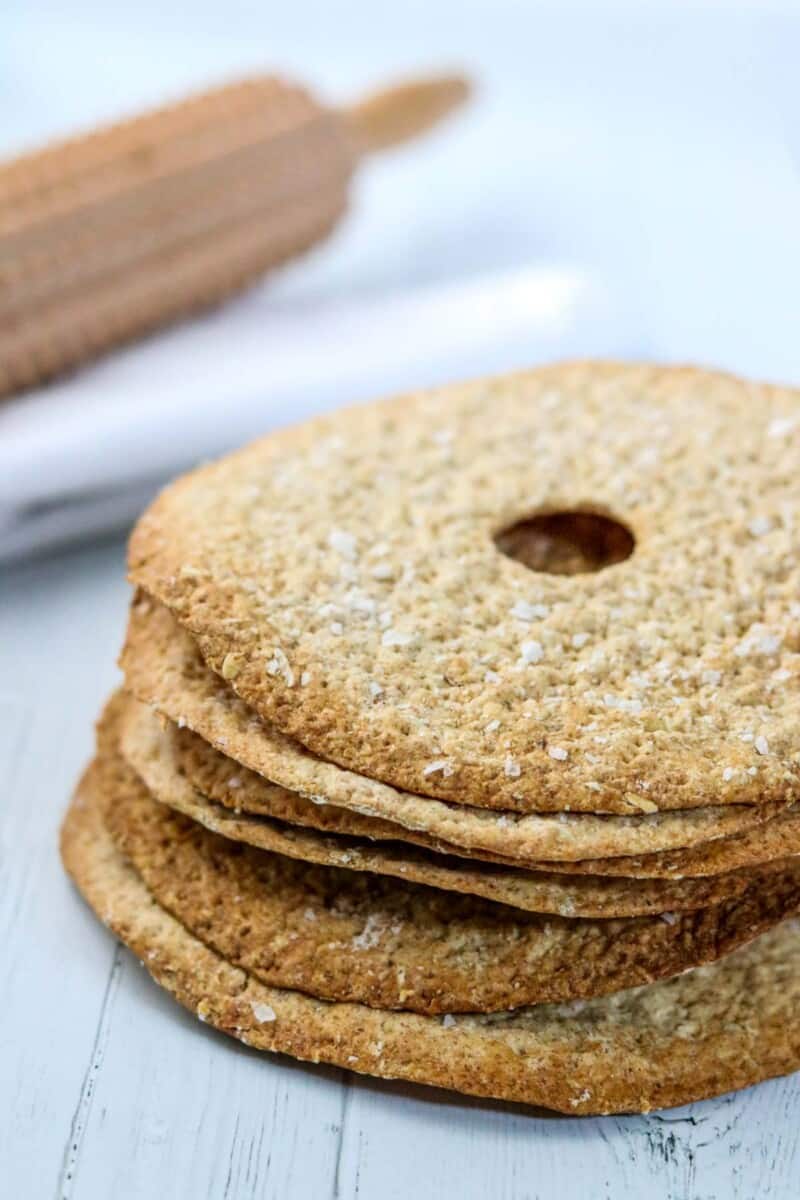 Swedish crispbread stacked next to a rolling pin.