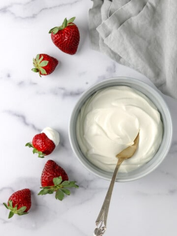 Whipped Vanilla Cream Skyr in a bowl next to strawberries.