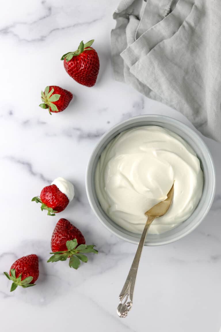 Whipped Vanilla Cream Skyr in a bowl next to strawberries.