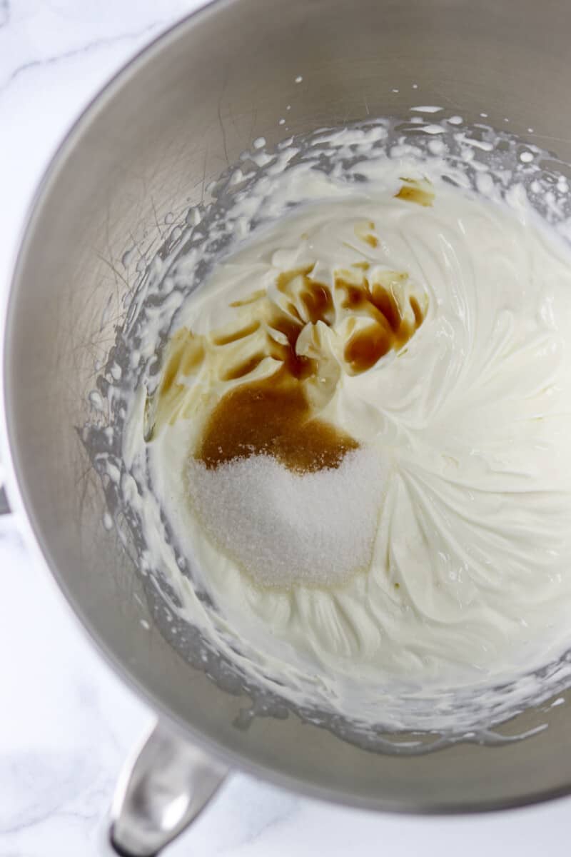 Cream, sugar and vanilla in a metal bowl.