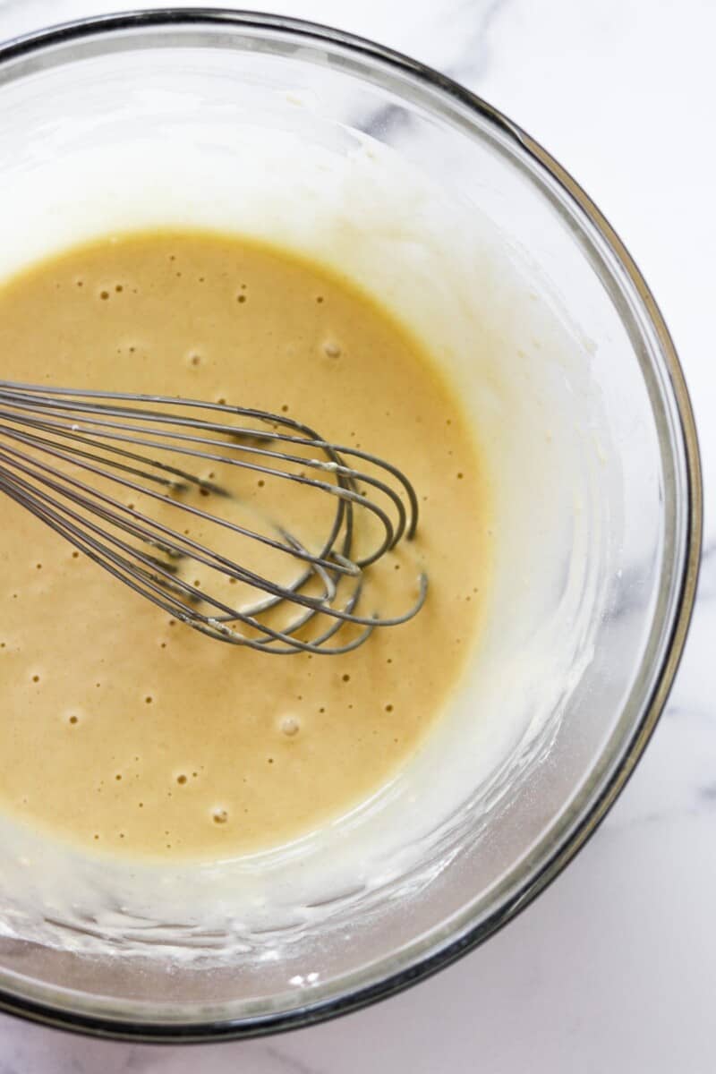 Batter in a glass bowl with a whisk.