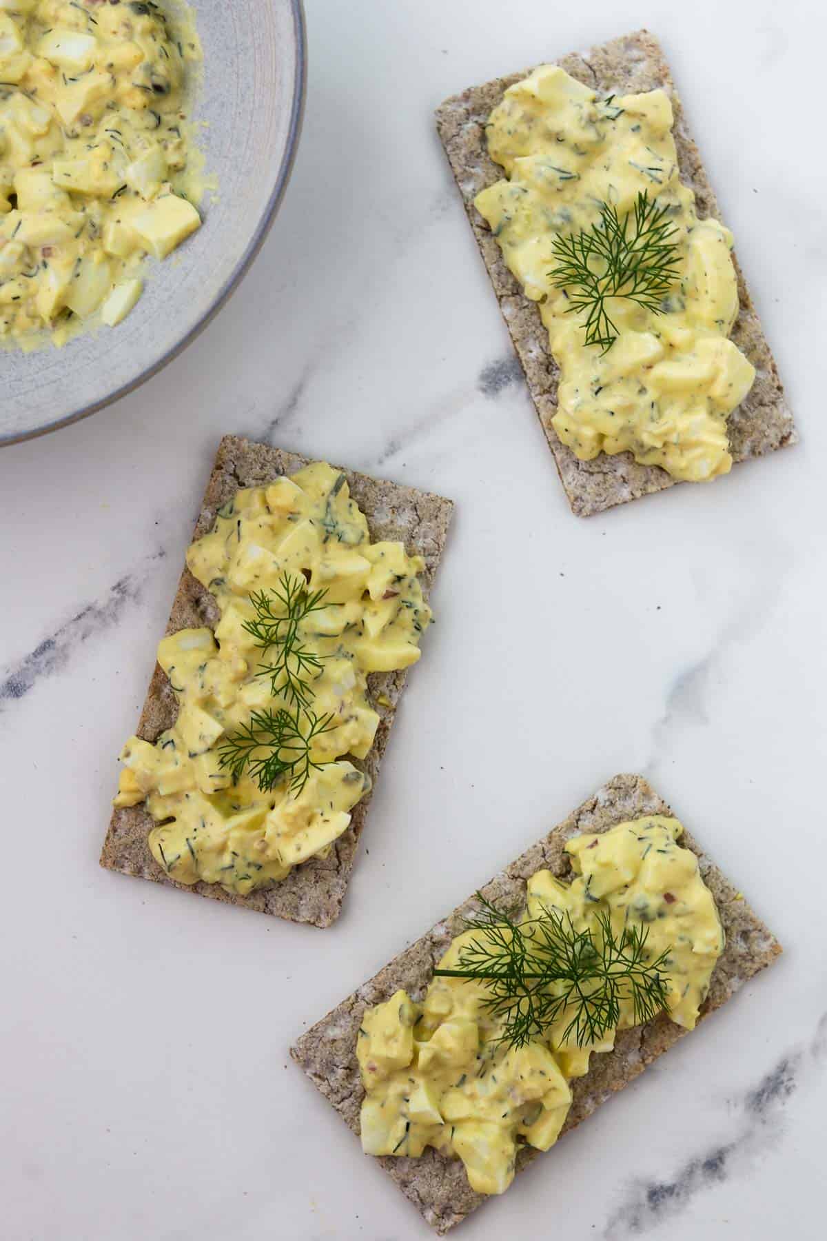 Overhead shot of egg salad on crackers.