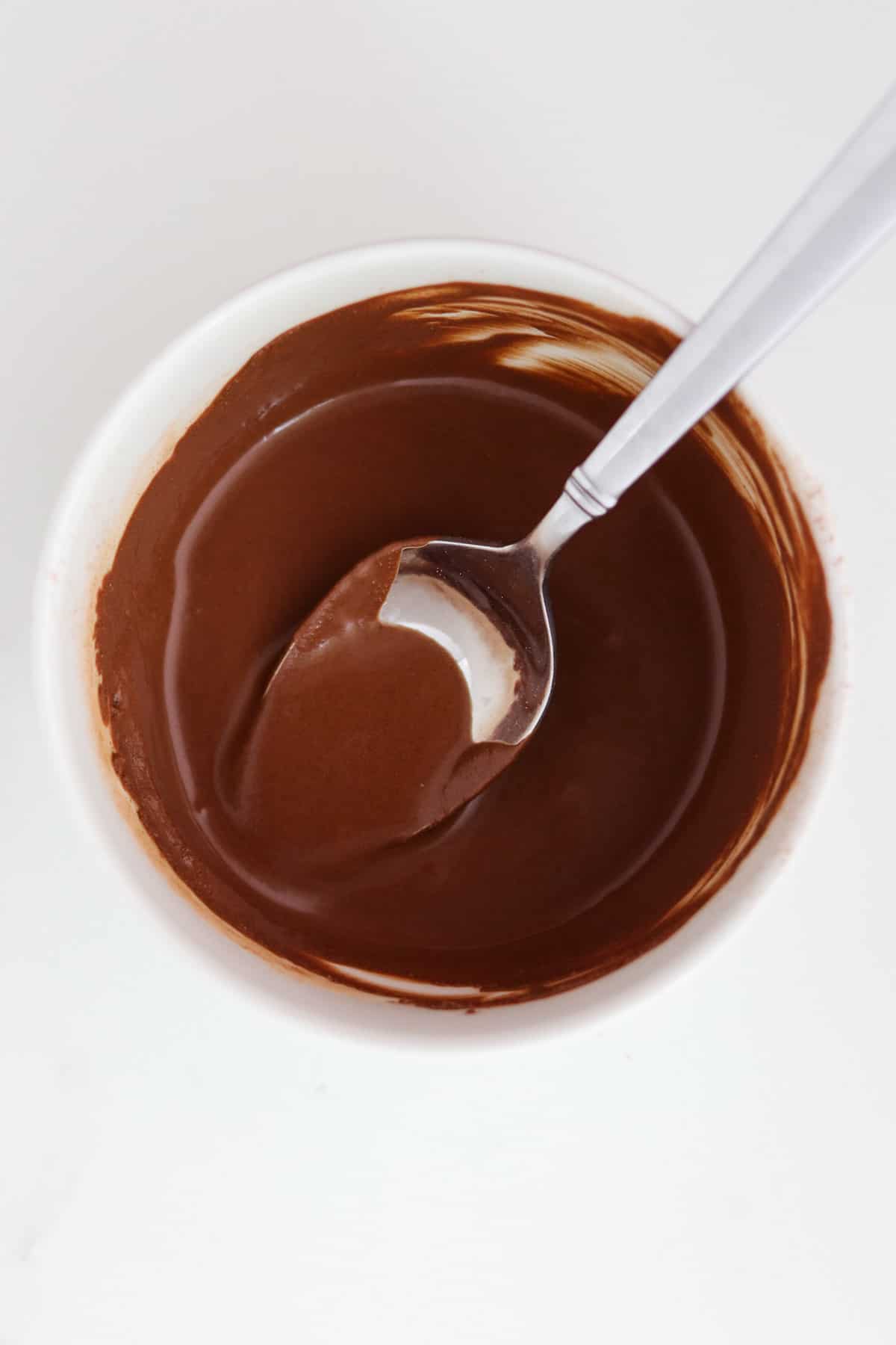 Melted chocolate in a bowl with a spoon.