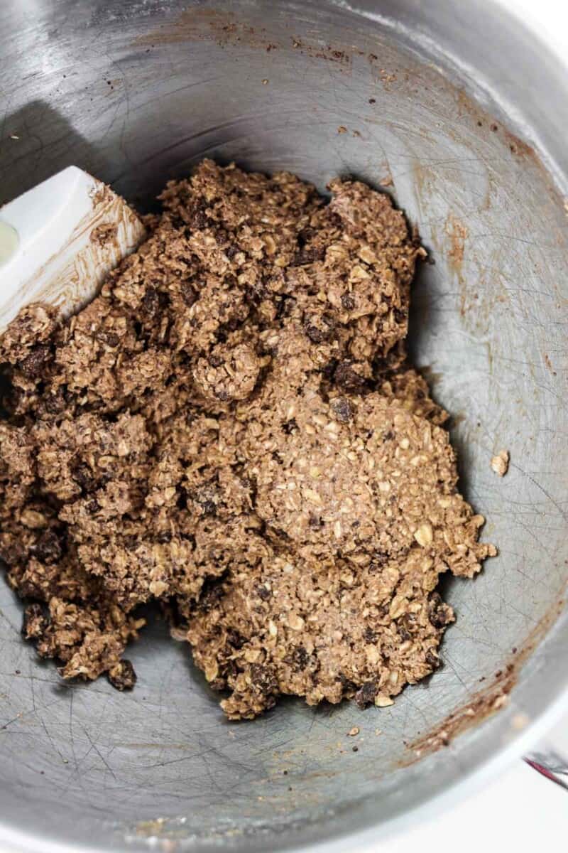 Cookie dough in a metal bowl with a spatula.