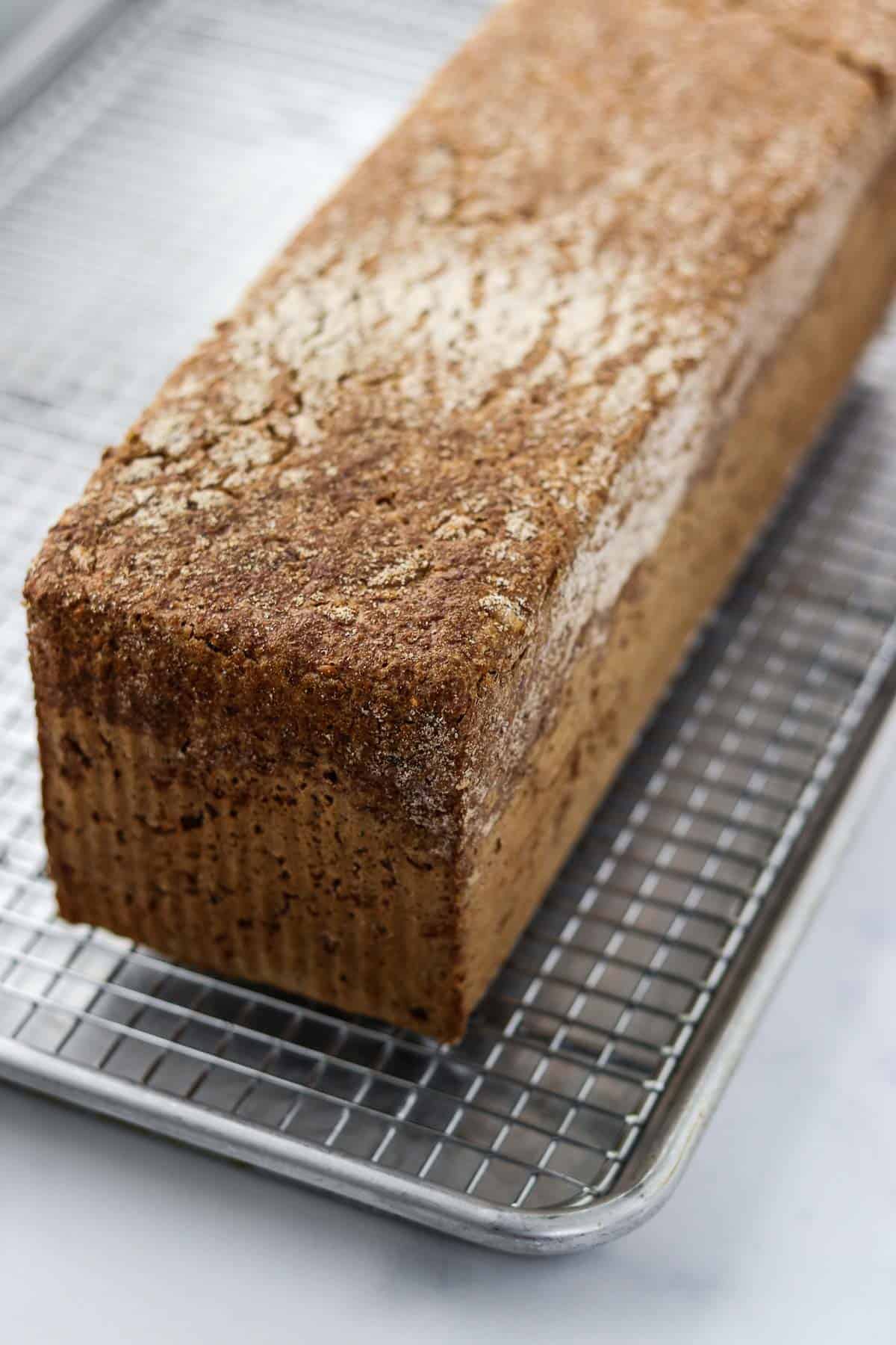 Danish rye bread on a metal cooling rack.
