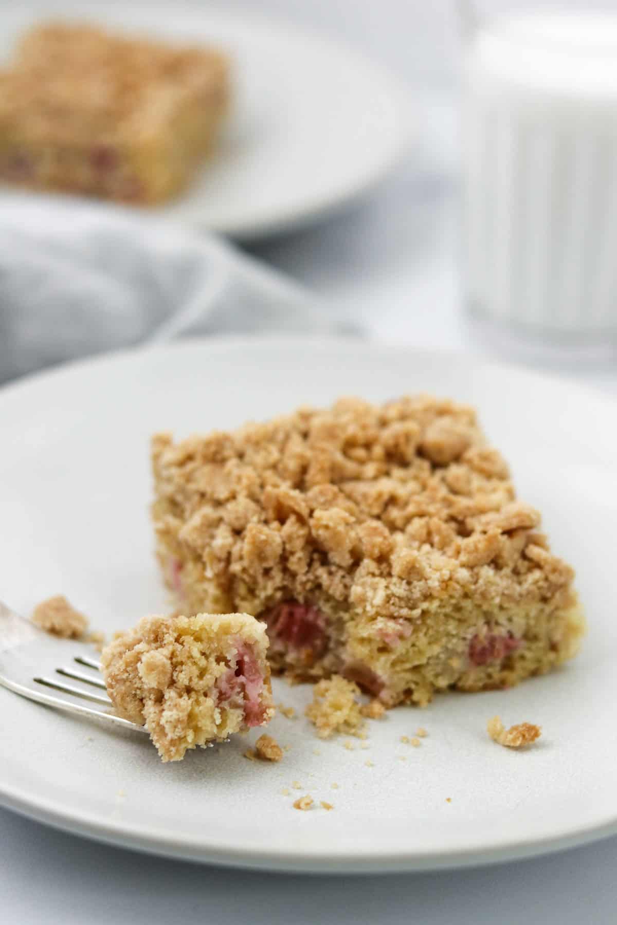 Rhubarb Crumb Cake on a plate with a bite on a fork.