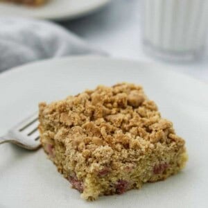 Old-Fashioned Norwegian Rhubarb Crumb Cake on a plate next to a glass of milk.
