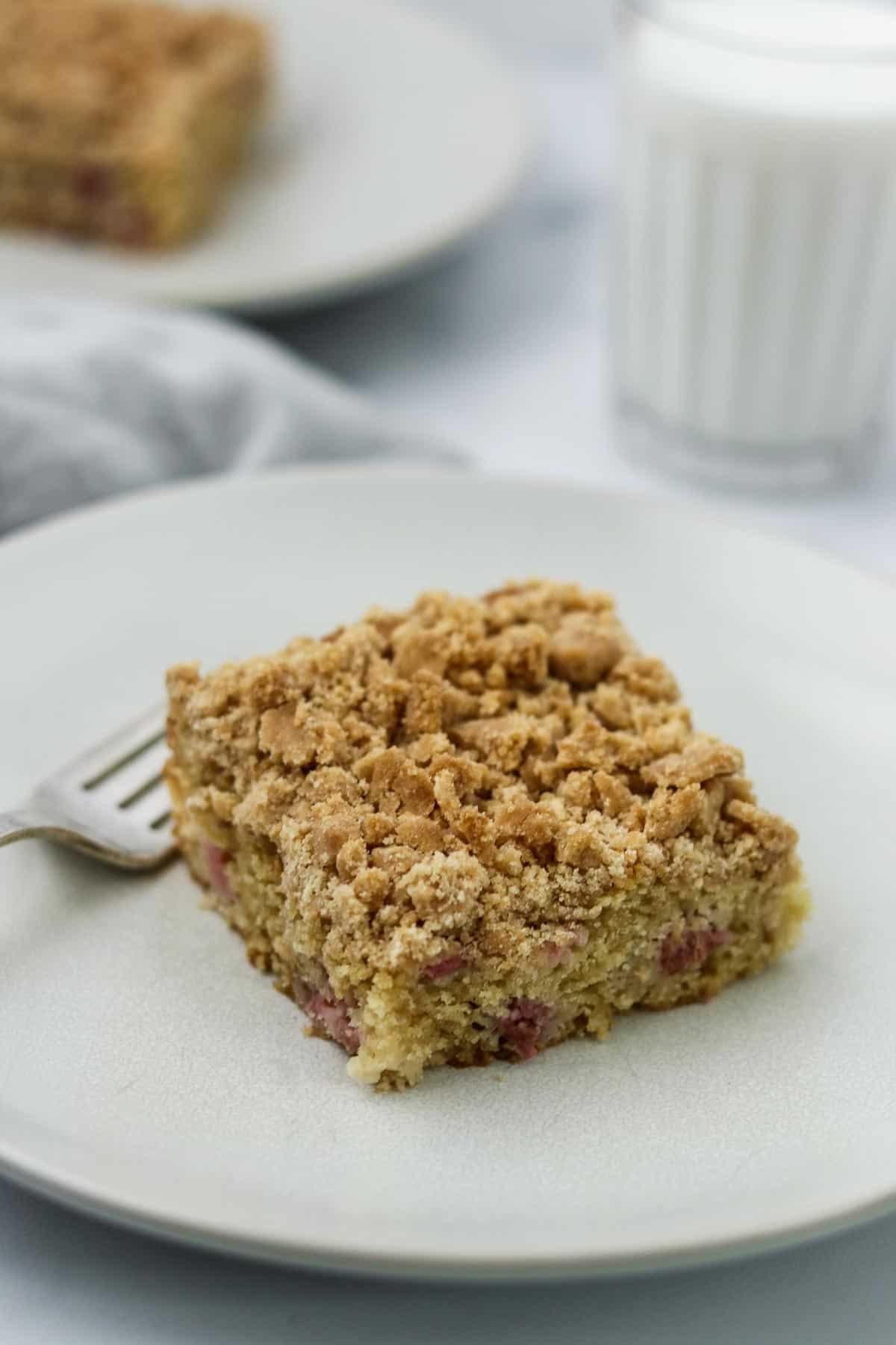 Old-Fashioned Norwegian Rhubarb Crumb Cake on a plate next to a glass of milk.