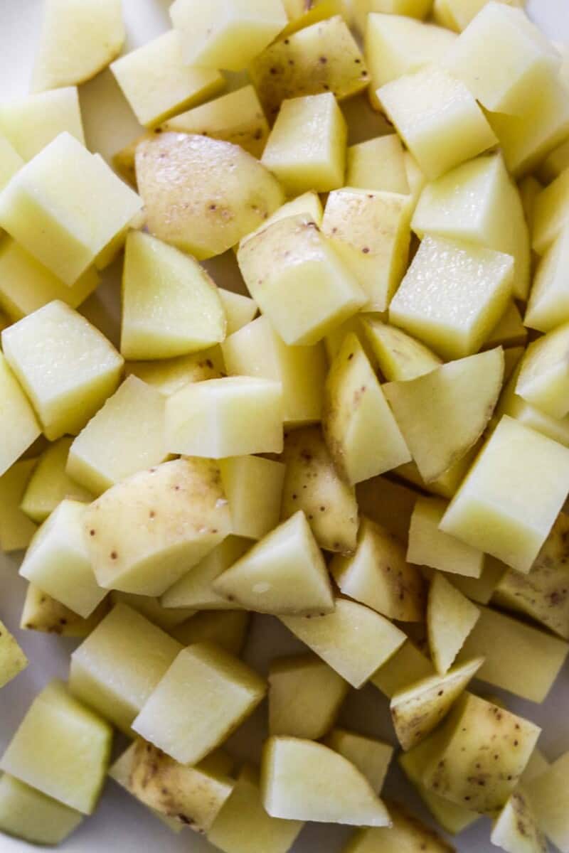 Cut up raw potatoes in a bowl.