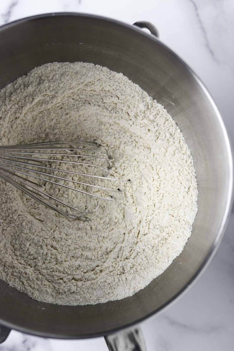 Flour in a metal bowl with a whisk.