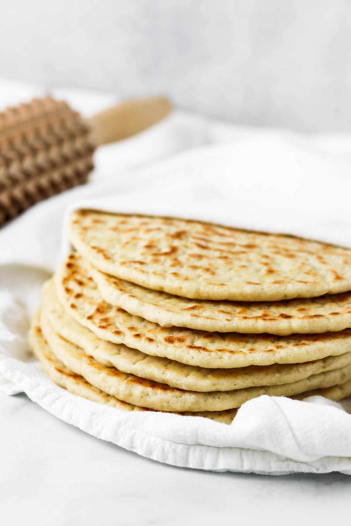 Stack of flatbreads on a towel.