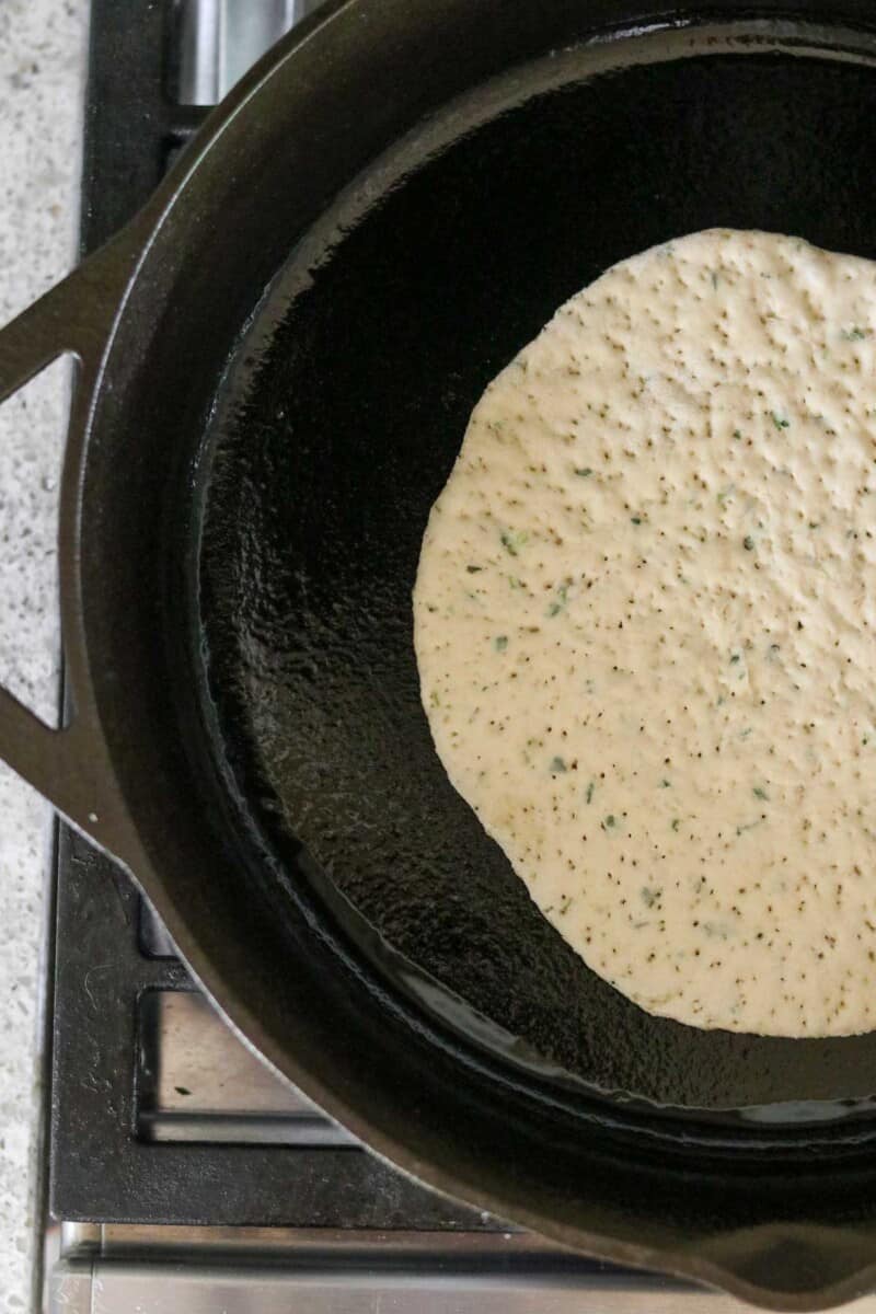 Flatbread cooking in a cast iron skillet.