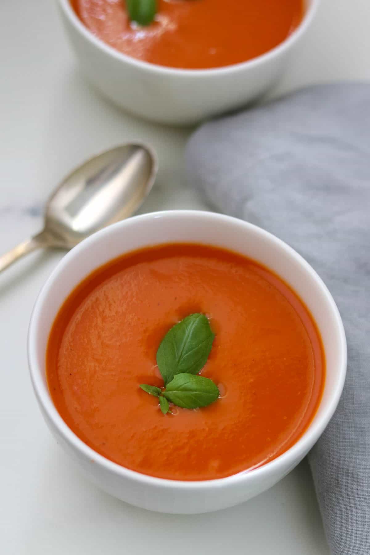 Creamy Roasted Tomato and Red Pepper Soup topped with basil.