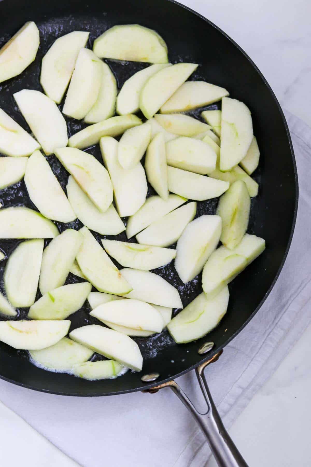 Apple slices in a skillet.