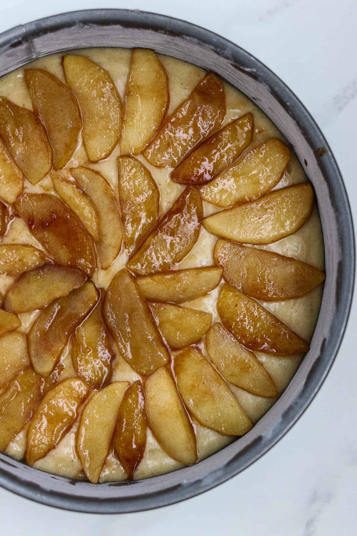 Unbaked apple cake in a pan.