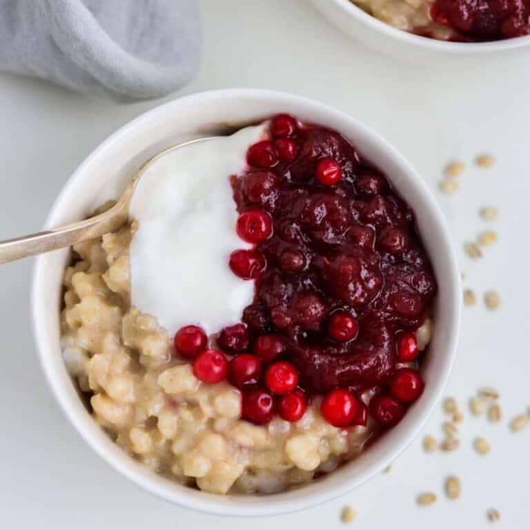 Close up of a bowl of Creamy Barley Breakfast Porridge with a spoon.