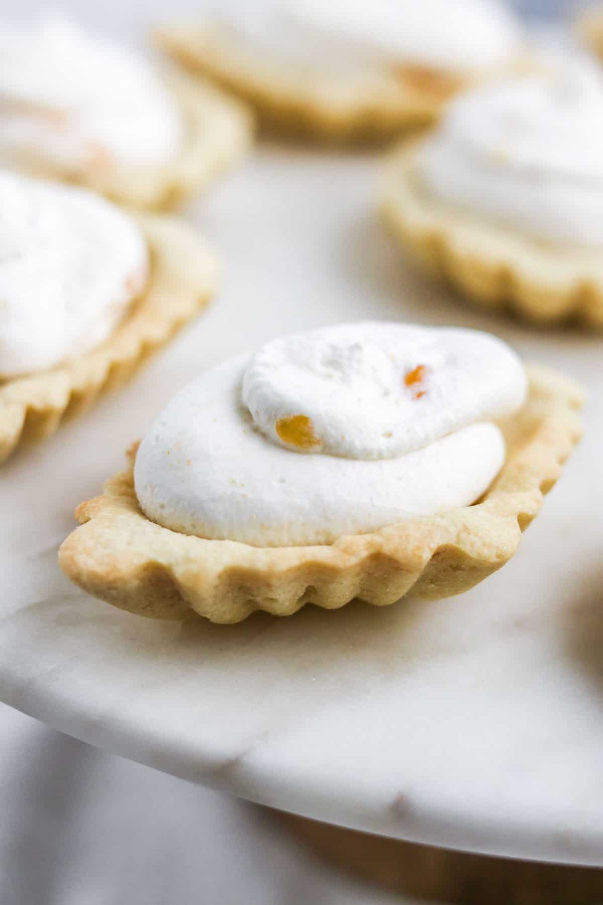A close up of an almond tart filled with cloudberry cream.